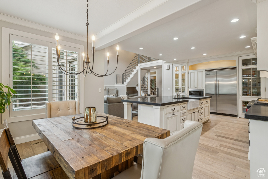 Dining area with crown molding, recessed lighting, light wood finished floors, plenty of natural light, and stairs