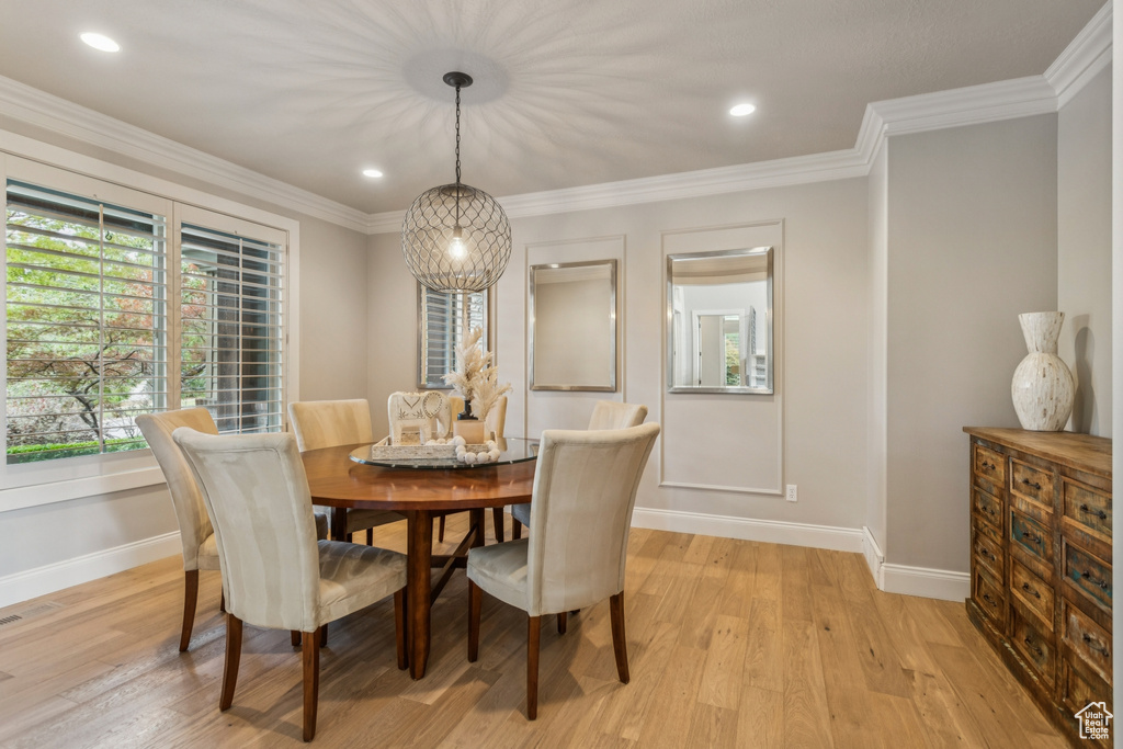 Dining area featuring light wood finished floors, ornamental molding, and recessed lighting