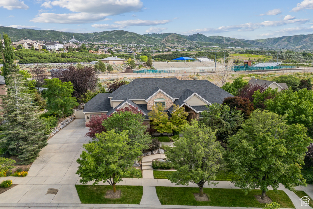 Aerial view of property and surrounding area featuring a mountainous background
