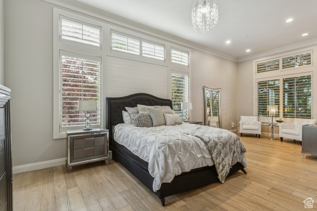 Bedroom featuring ornamental molding, light wood-style floors, a chandelier, and recessed lighting