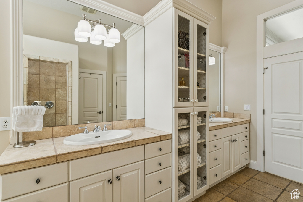 Full bathroom featuring vanity, ornamental molding, and stone finish floors