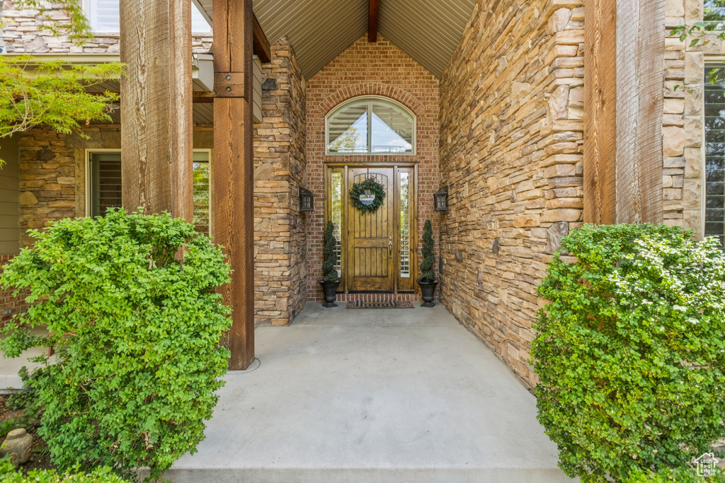 View of exterior entry with stone siding and brick siding