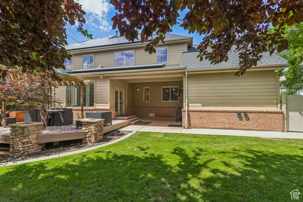 Back of property with a patio area and solar panels