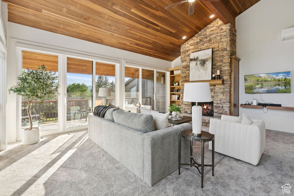 Carpeted living room featuring wood ceiling, ceiling fan, a fireplace, and high vaulted ceiling