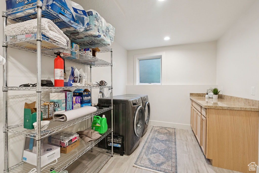 Laundry area featuring light wood-type flooring, separate washer and dryer, and recessed lighting