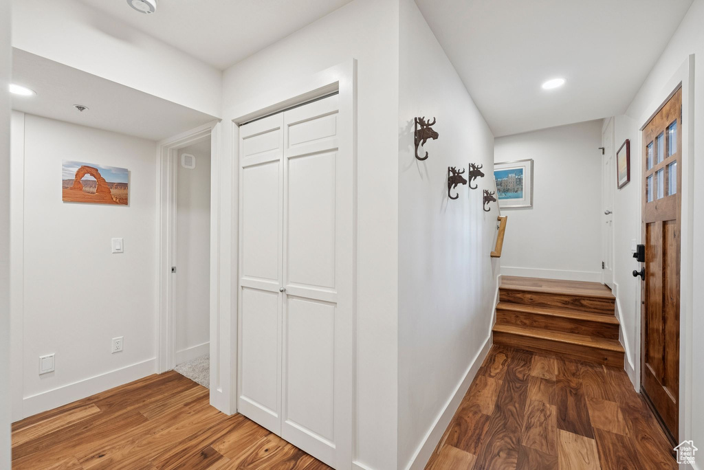 Hallway with wood finished floors and recessed lighting