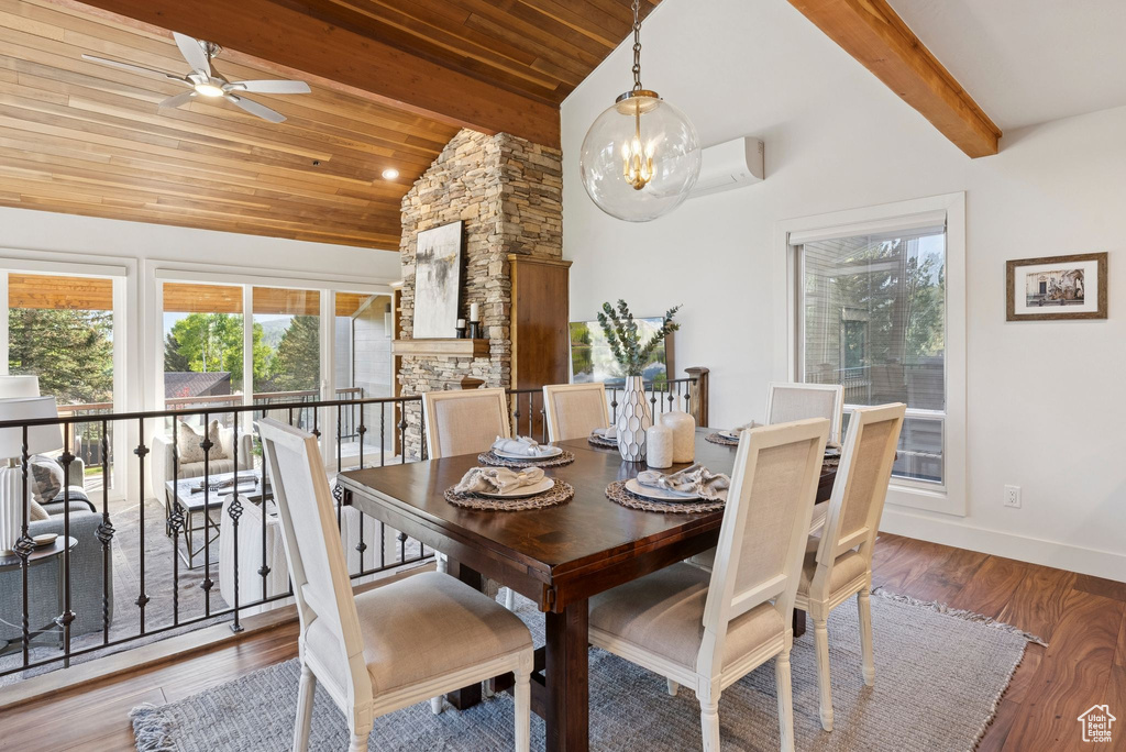 Dining area featuring a wall unit AC, wooden ceiling, wood finished floors, and ceiling fan