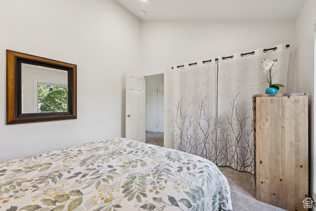 Bedroom featuring carpet and high vaulted ceiling