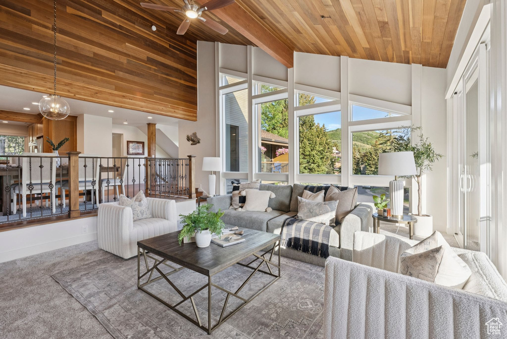 Living area featuring wood ceiling, a ceiling fan, high vaulted ceiling, and carpet floors