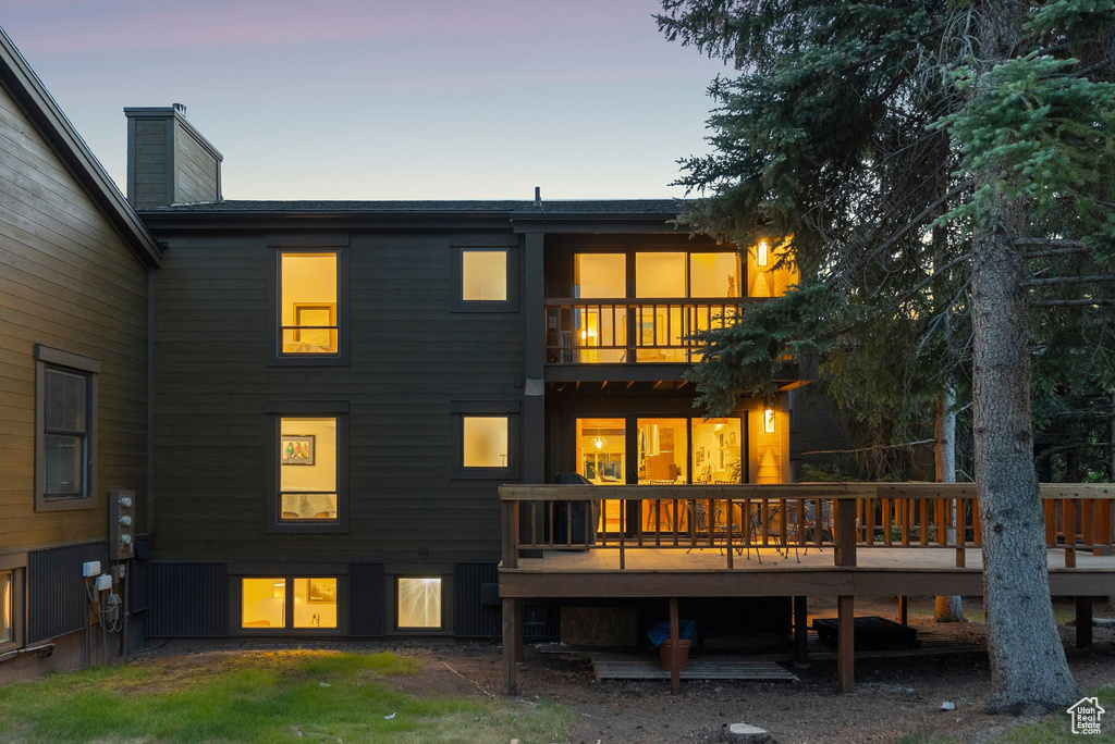 Rear view of property featuring a deck and a balcony
