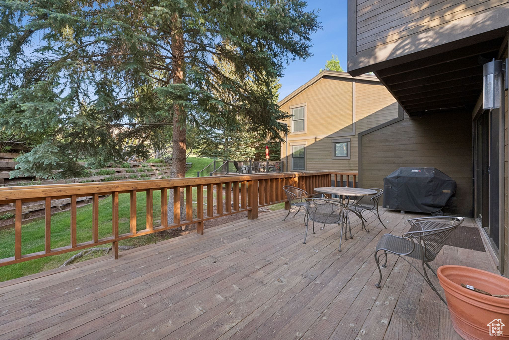 Wooden deck featuring area for grilling and outdoor dining area
