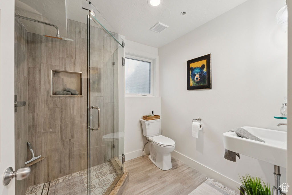 Full bath featuring wood finished floors and a stall shower