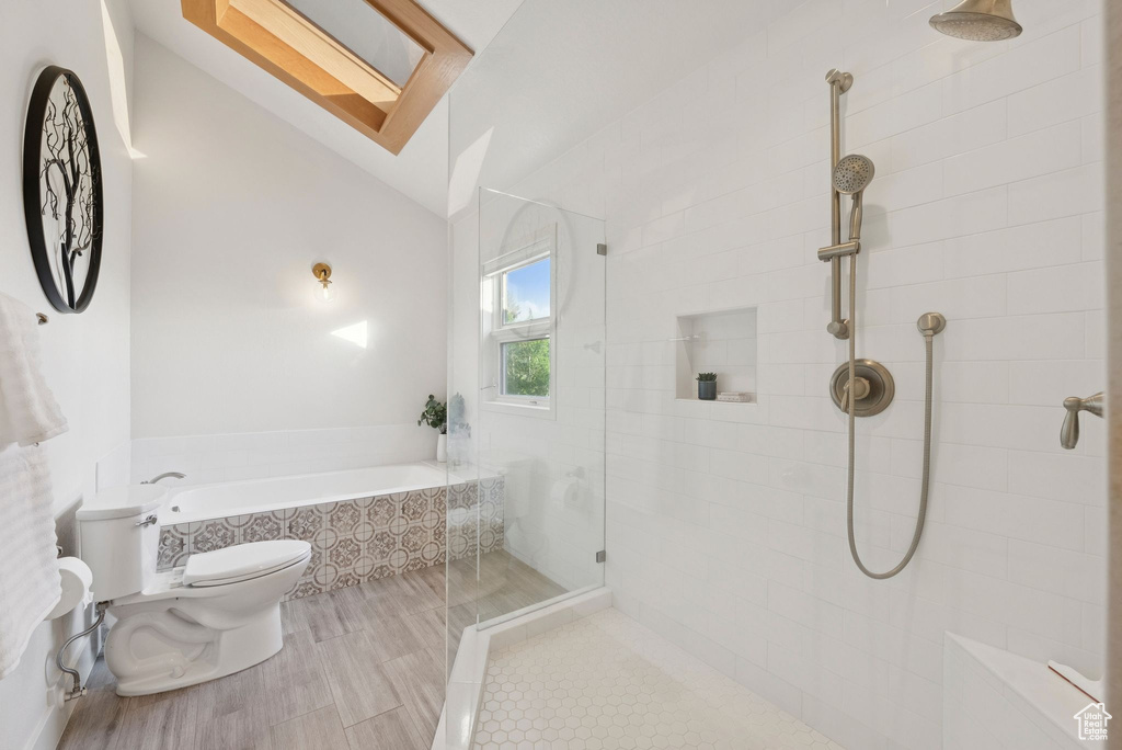 Bathroom featuring a garden tub, tiled shower, and lofted ceiling