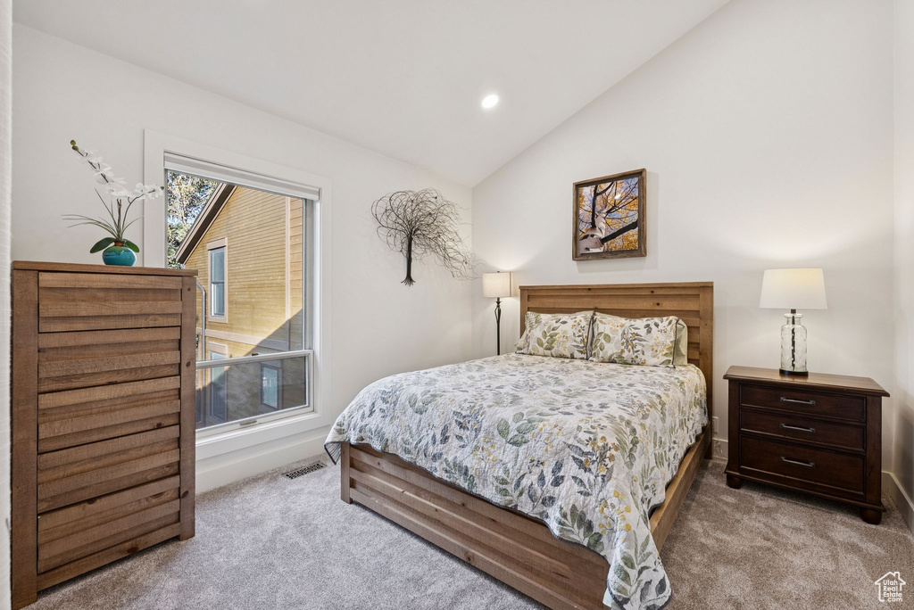 Carpeted bedroom with vaulted ceiling and recessed lighting