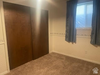 Unfurnished bedroom featuring carpet floors and baseboards