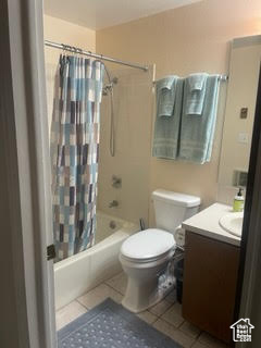 Bathroom with tile patterned floors, vanity, and shower / tub combo with curtain