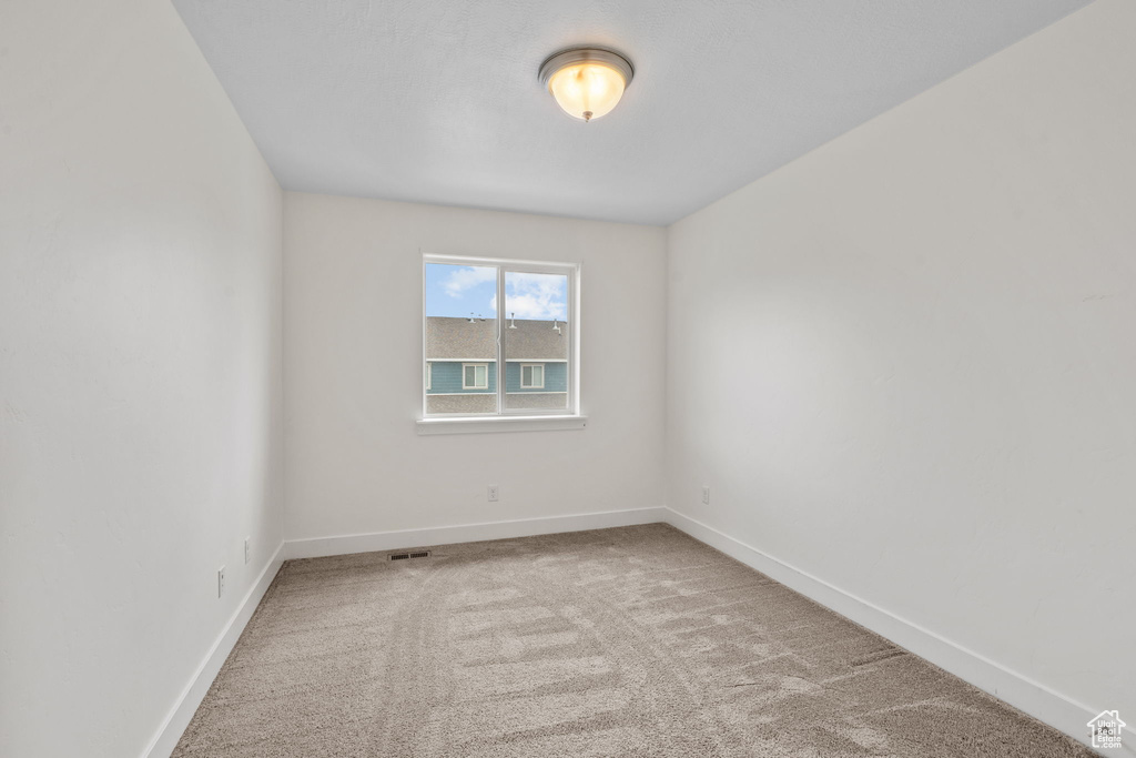 Carpeted empty room with baseboards