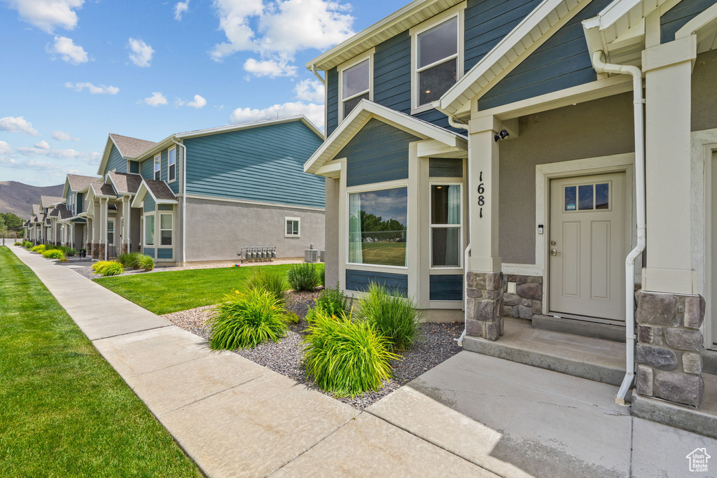 Property entrance featuring a lawn, stone siding, stucco siding, and a residential view