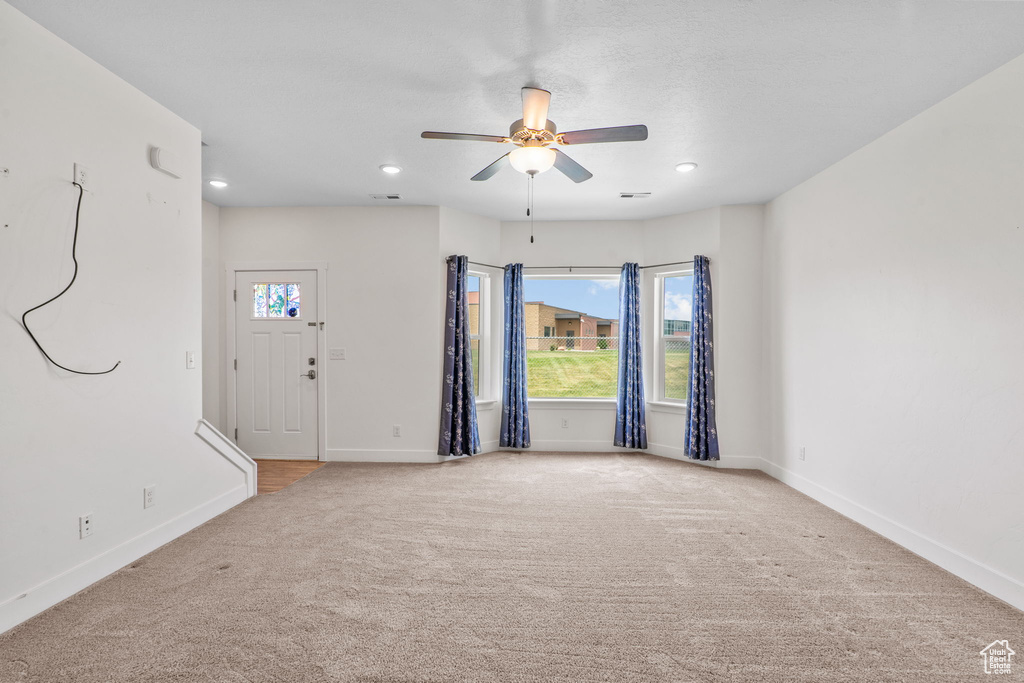 Empty room featuring light colored carpet, a ceiling fan, and recessed lighting