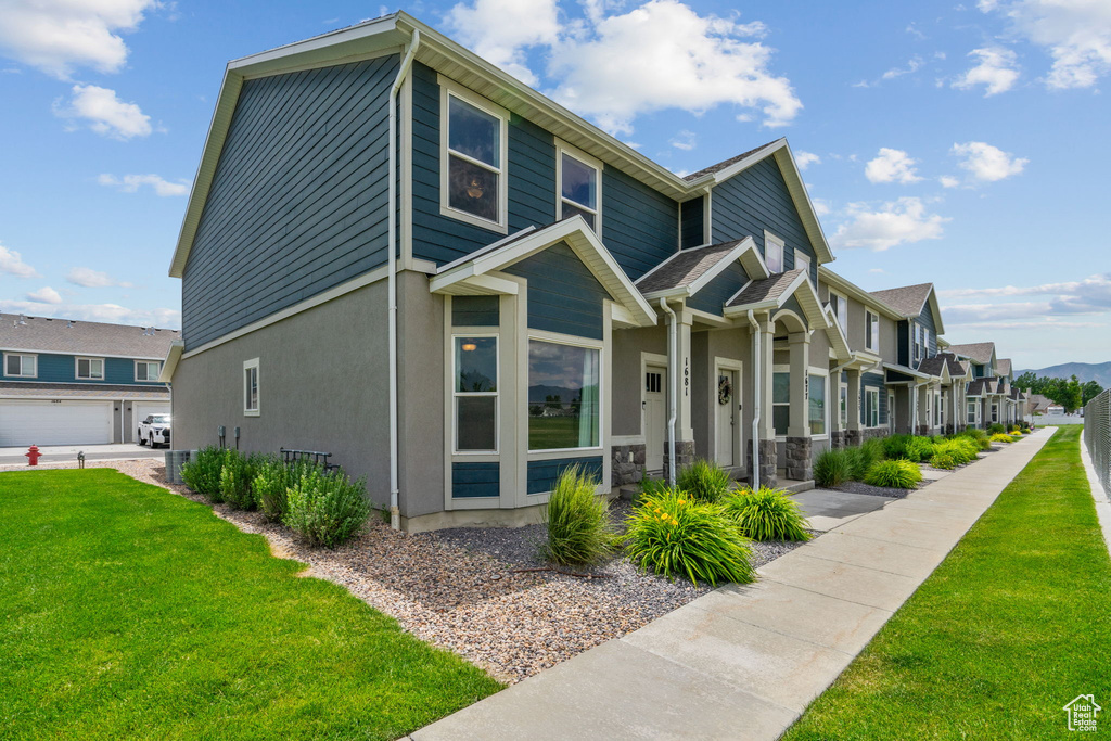 View of front facade with a residential view, a front lawn, and stucco siding