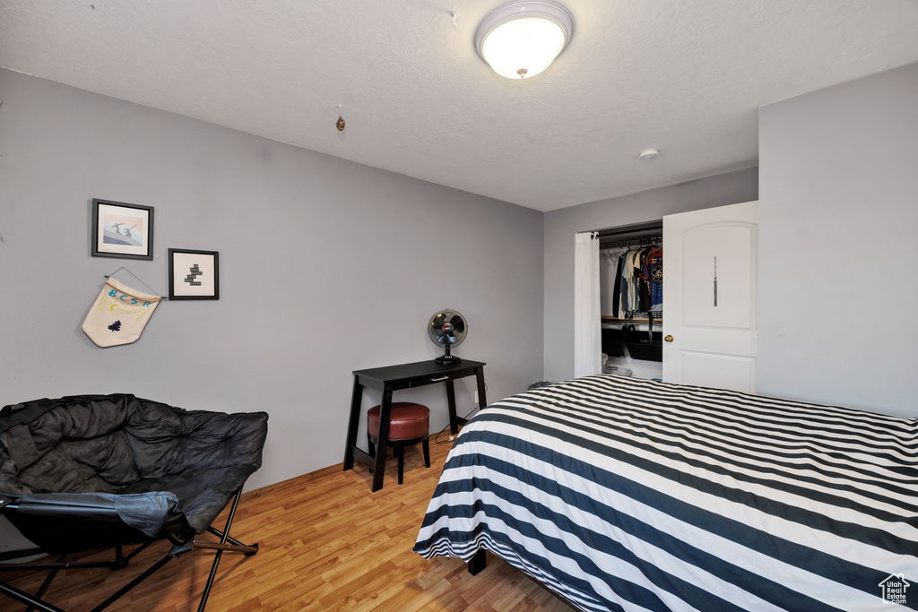 Bedroom with light wood-style floors and a closet