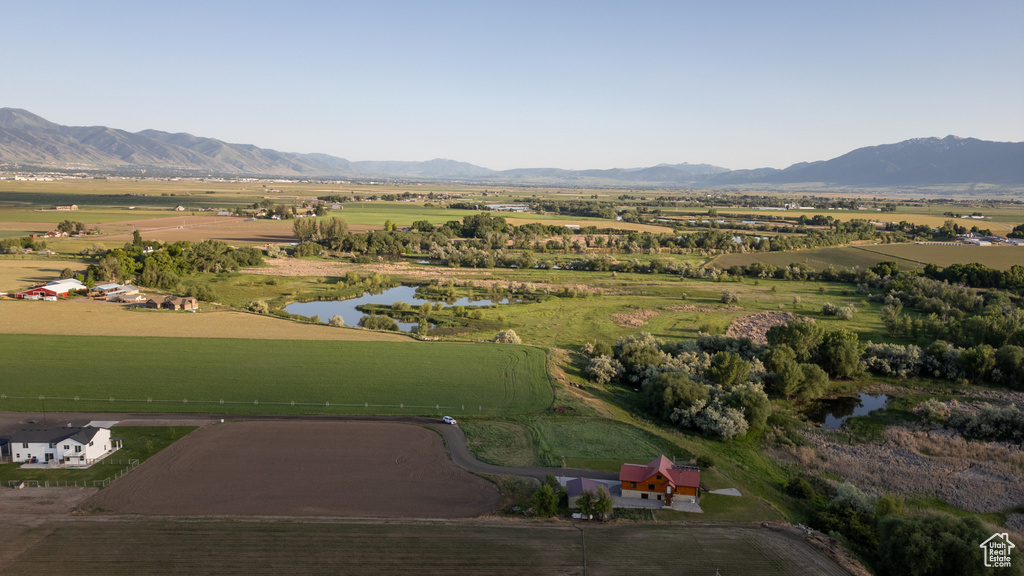 Aerial view of property and surrounding area featuring rural landscape and a water and mountain view