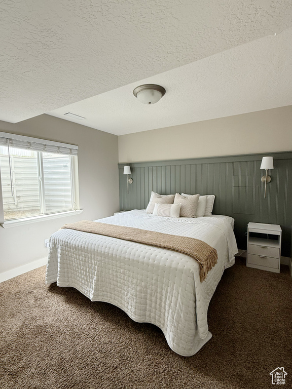 Bedroom featuring carpet floors and a textured ceiling