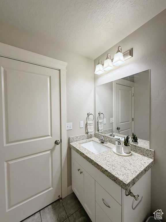 Bathroom featuring vanity, tile patterned floors, and a textured ceiling