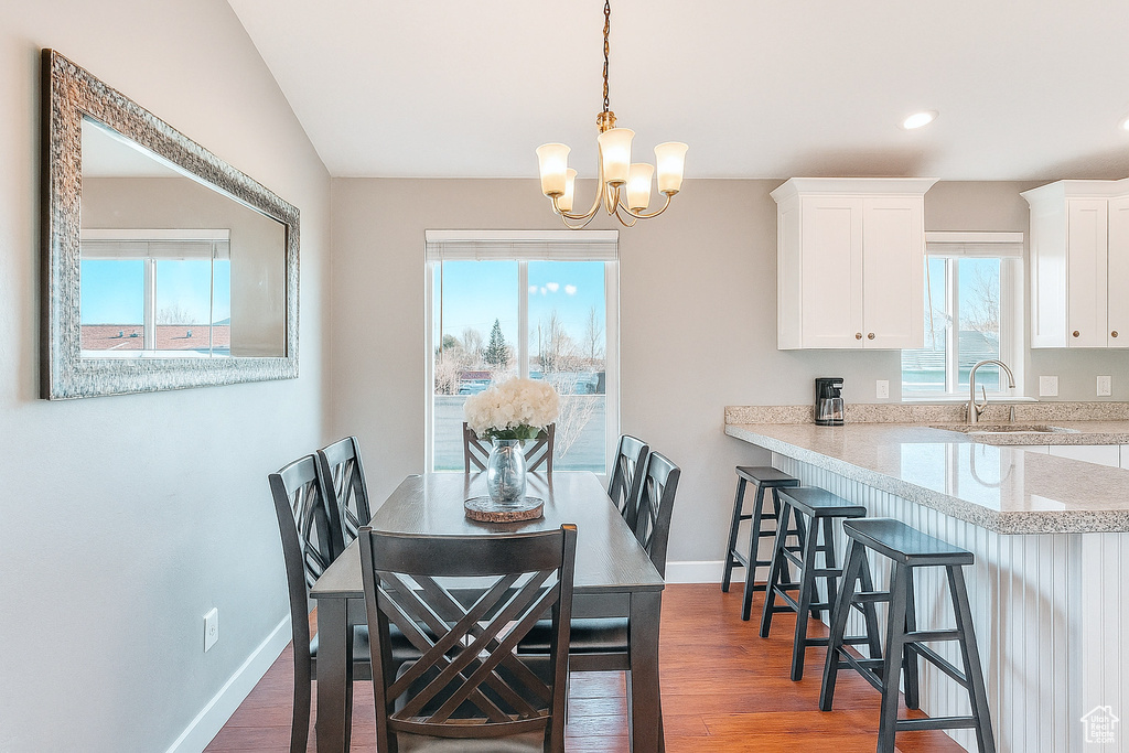 Dining room with a chandelier, wood finished floors, and recessed lighting