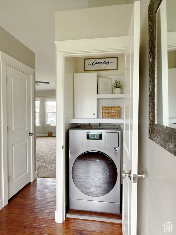 Laundry room with washer / dryer, cabinet space, and wood finished floors