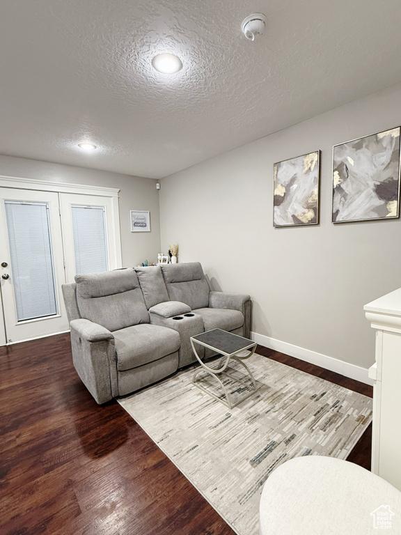 Living area featuring wood finished floors, a textured ceiling, and recessed lighting