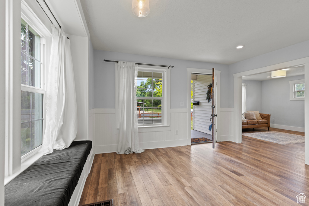Foyer entrance featuring light wood-style flooring and a wainscoted wall