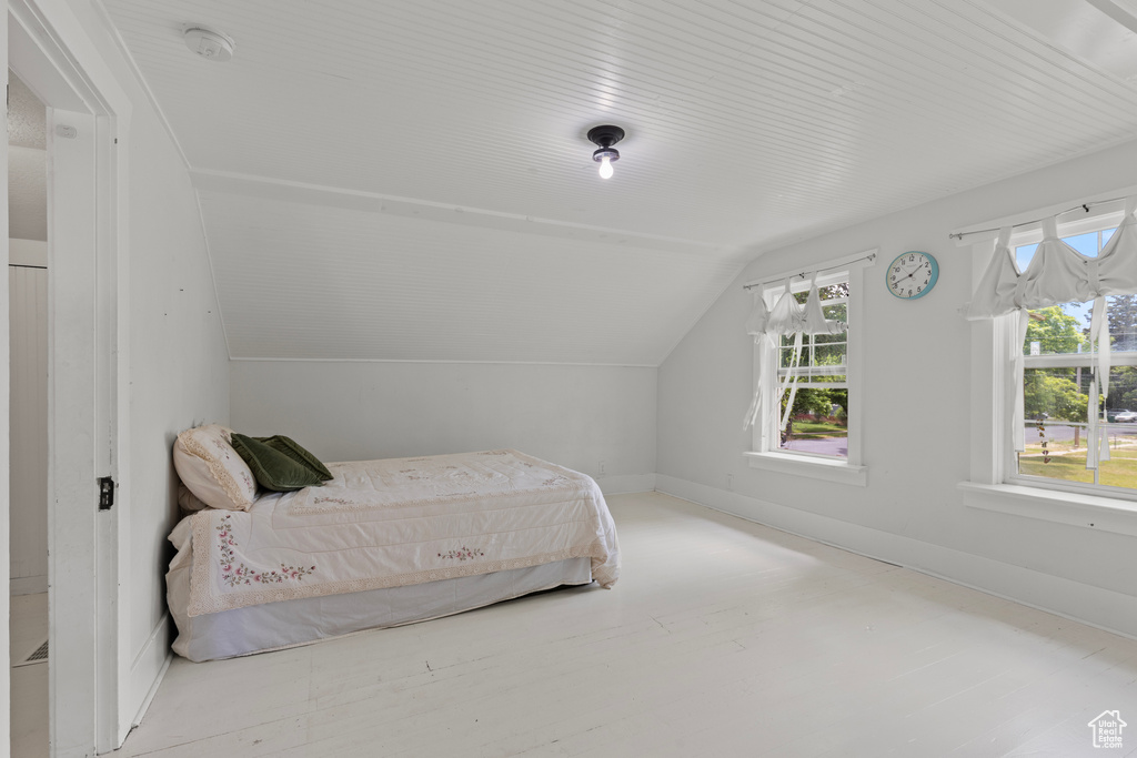 Bedroom featuring lofted ceiling and baseboards