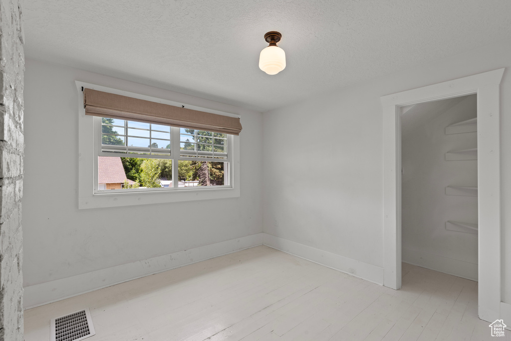 Unfurnished bedroom featuring a textured ceiling and light wood-style flooring