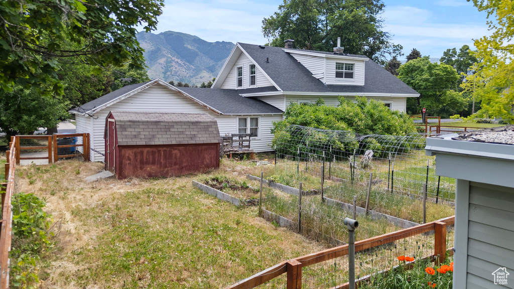 View of yard featuring a garden, a shed, and a mountain view