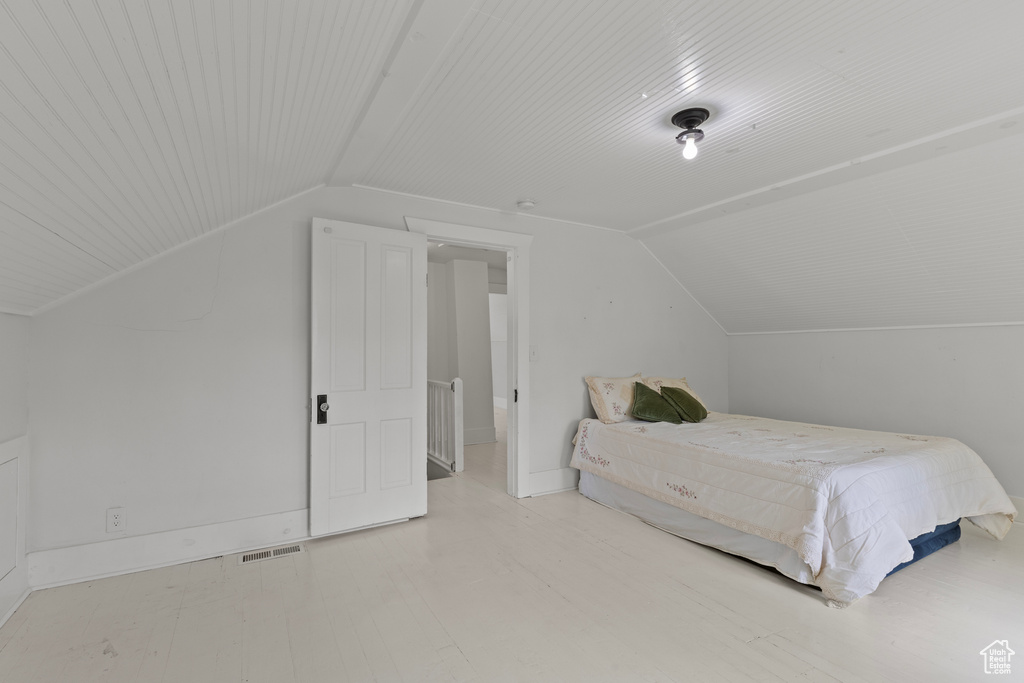 Bedroom featuring vaulted ceiling and baseboards