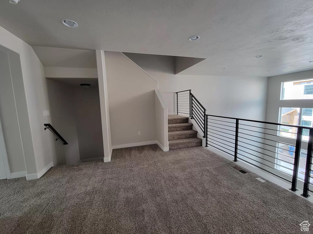 Stairs with carpet and recessed lighting