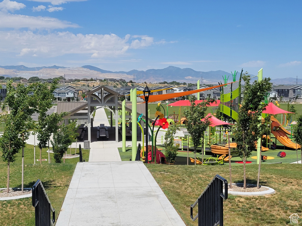 View of community featuring a playground, a lawn, and a mountain view