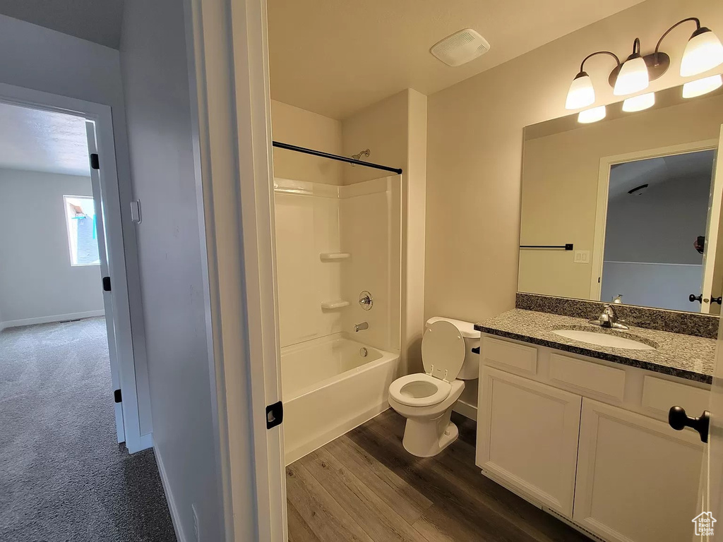 Bathroom featuring vanity, bathtub / shower combination, and wood finished floors