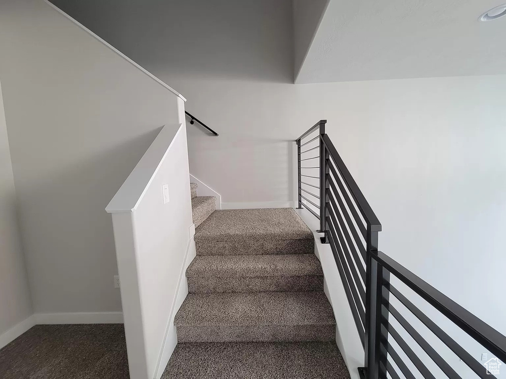 Staircase with carpet floors and baseboards