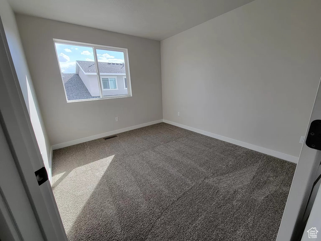 Carpeted empty room with baseboards