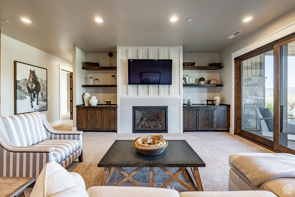 Living area featuring carpet floors, a fireplace, and recessed lighting