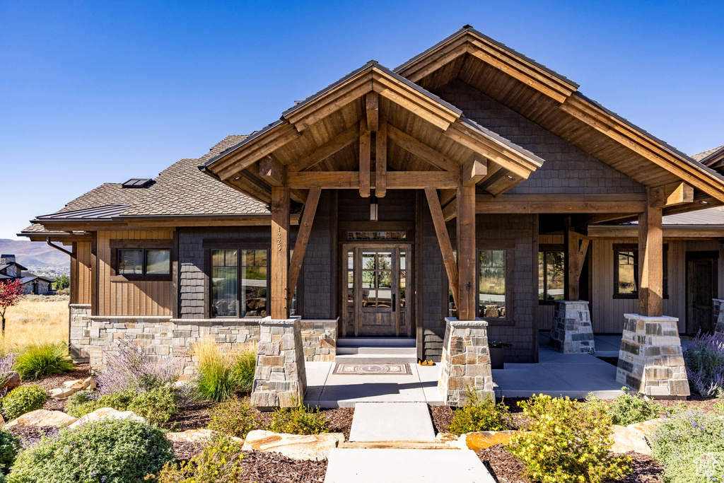 Property entrance with a porch and stone siding