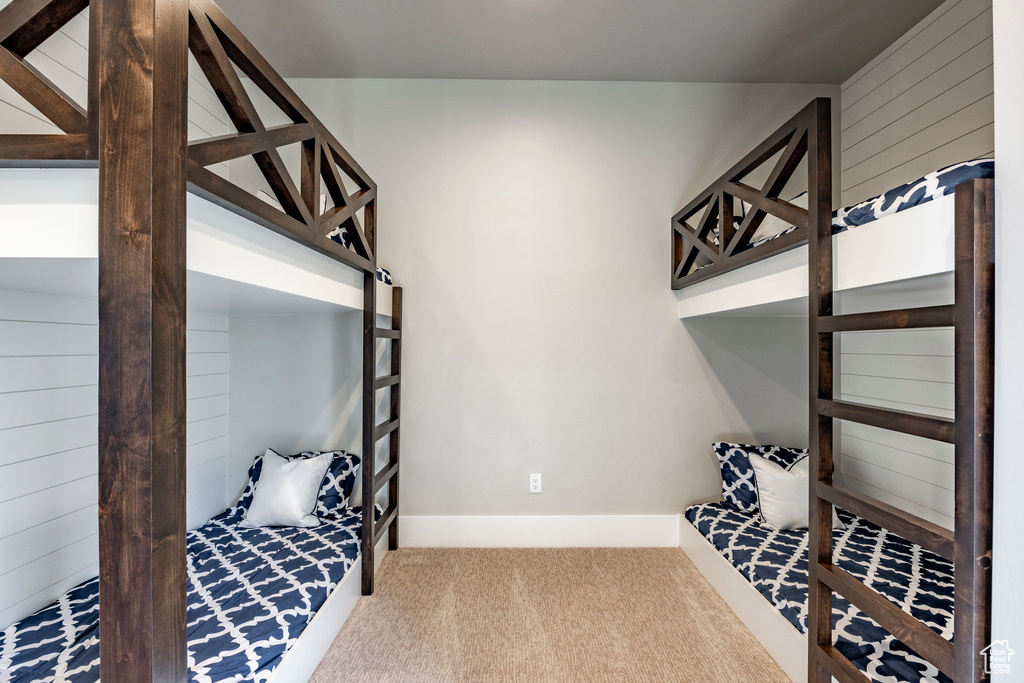 Bedroom featuring carpet flooring and wood walls