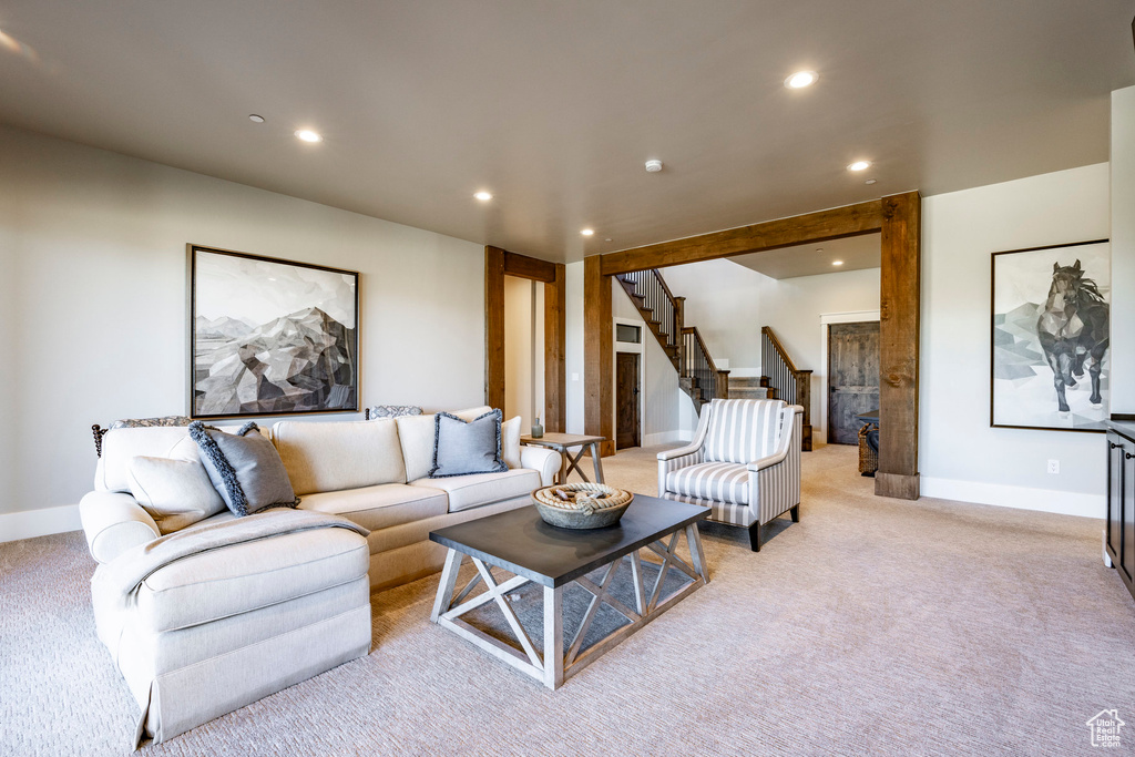Living room featuring recessed lighting, light carpet, and stairway