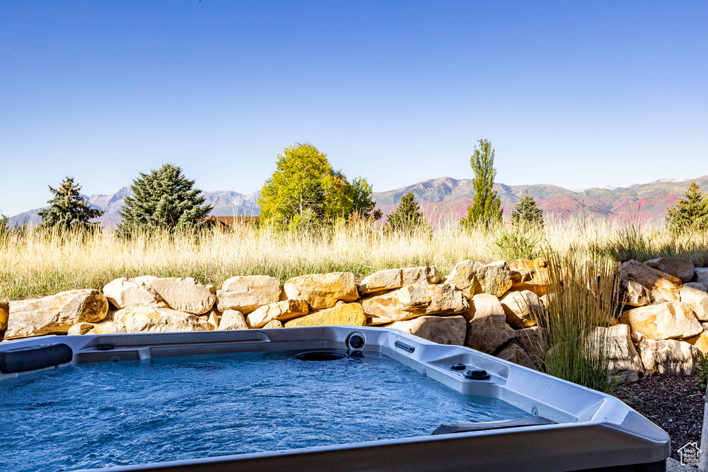 View of pool featuring a mountain view and a hot tub