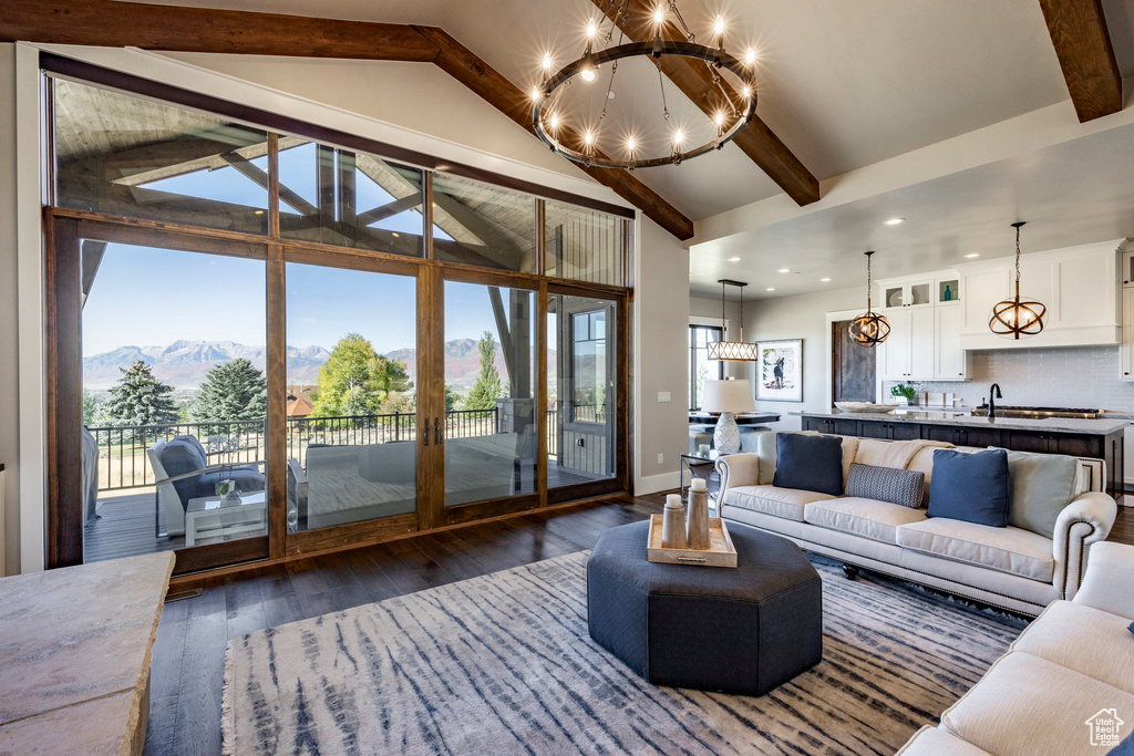 Living room with a chandelier, dark wood-style flooring, beamed ceiling, a mountain view, and recessed lighting