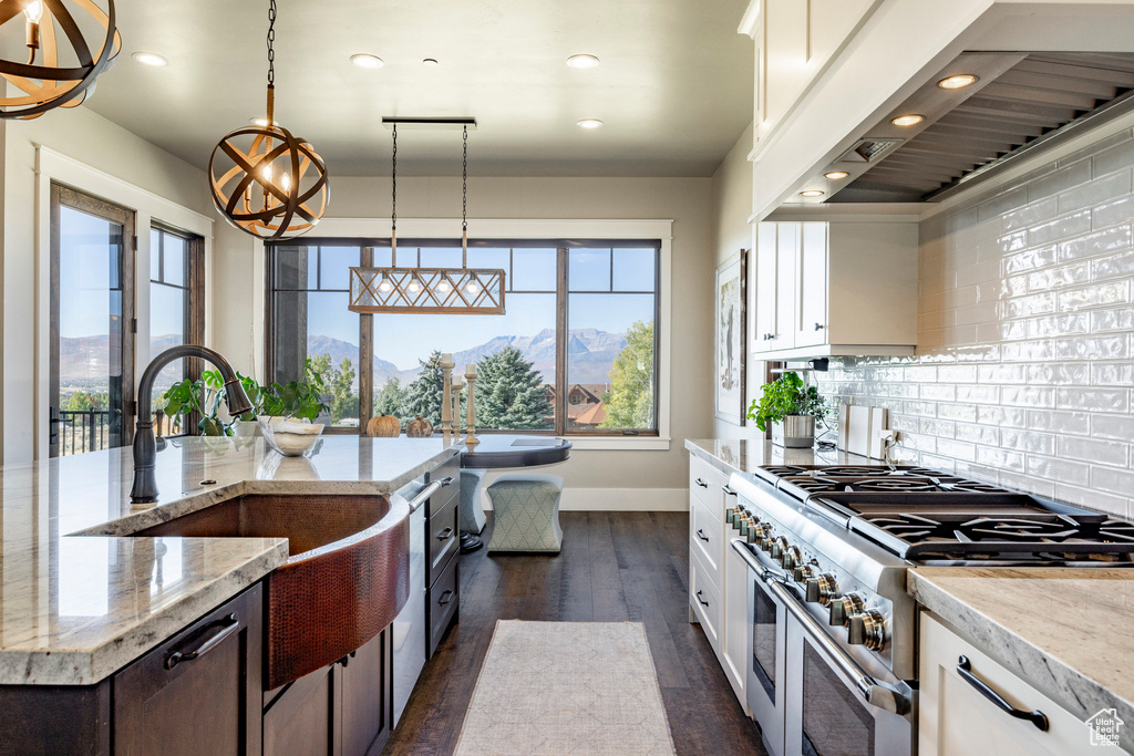 Kitchen featuring range with two ovens, premium range hood, recessed lighting, plenty of natural light, and decorative backsplash