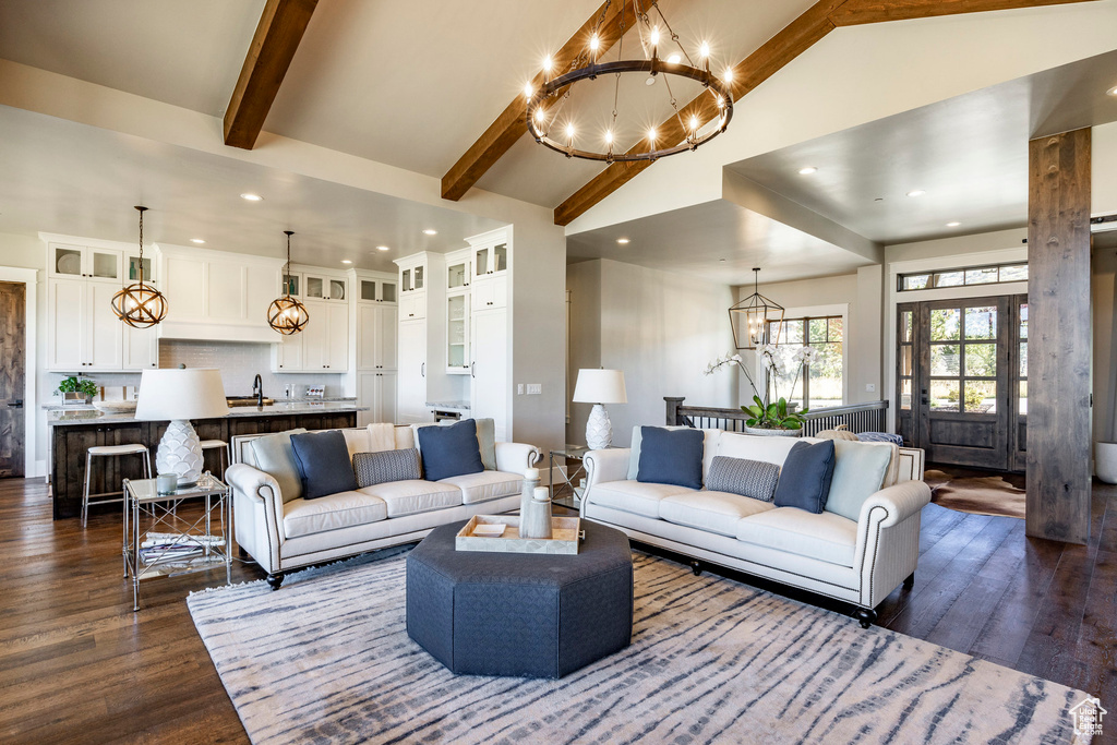Living room featuring a chandelier, dark wood finished floors, high vaulted ceiling, beam ceiling, and recessed lighting