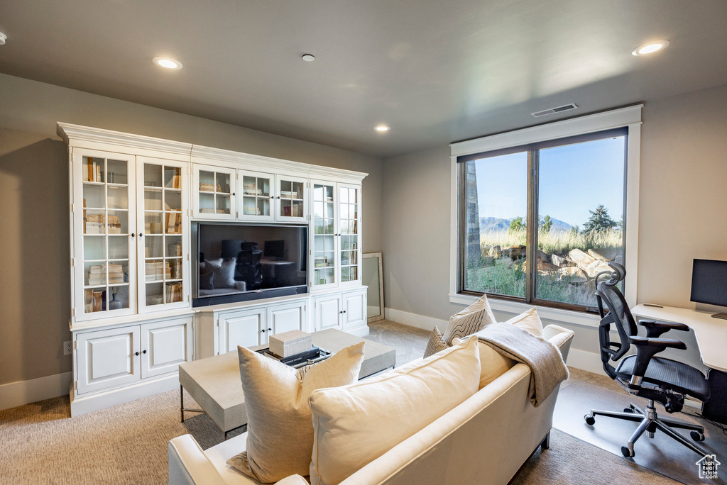 Living room featuring light colored carpet, an office area, and recessed lighting